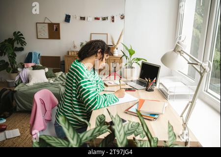 Teenager-Mädchen, das am Schreibtisch im Schlafzimmer studiert Stockfoto