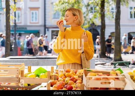 Frau riecht frische Äpfel auf dem Bauernmarkt Stockfoto