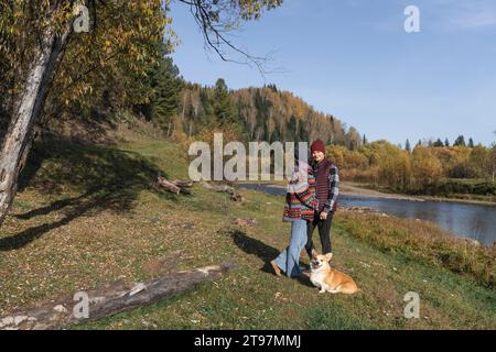 Ein Paar, das sich von Pembroke walisischen Corgi im Naturpark umgibt Stockfoto