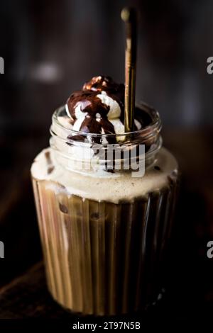 Tasse Eiskaffee mit Schlagsahne und Schokoladensauce Stockfoto