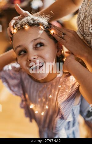 Frau, die zu Hause Schnur auf die Stirn der Tochter stellt Stockfoto