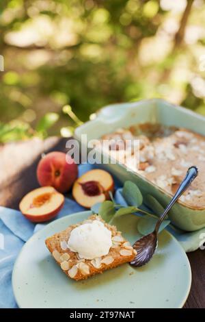 Scheibe Pfirsichkuchen mit Mandeln und Eis Stockfoto