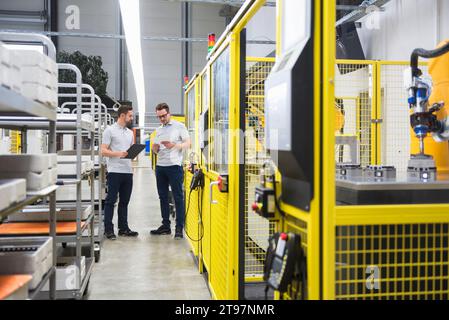 Ingenieure mit Dateiordner, die werkseitig diskutiert werden Stockfoto