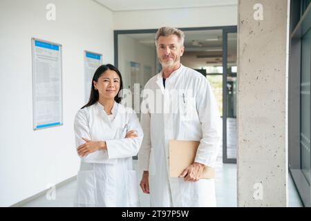 Lächelnde Wissenschaftler stehen im Flur des Labors Stockfoto