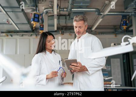 Wissenschaftler diskutieren über Tablet-PC im Labor Stockfoto