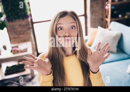 Porträt von gegossenen Lippen funky Teenager Mädchen sagen, boo gruselige Grimasse erhöhte Palmen hoch Scherzbart mit blonden Haaren im Wohnzimmer Stockfoto
