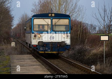 České dráhy (Tschechische Eisenbahnen) kleiner Dieselzug (Modell Motorový vůz 811), der zum Bahnhof Dobrovíz fährt Stockfoto