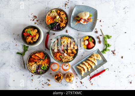 Eine Auswahl an gut servierten chinesischen Speisen. Chinesische Nudeln, gebratener Reis, Knödel, Fußgängerente, Dim Sum, Federrollen. Berühmte chinesische Küche auf t Stockfoto