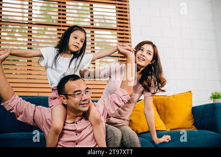 Eine fröhliche Familie in ihrem komfortablen, modernen Haus genießt eine schöne Zeit auf dem Sofa Stockfoto