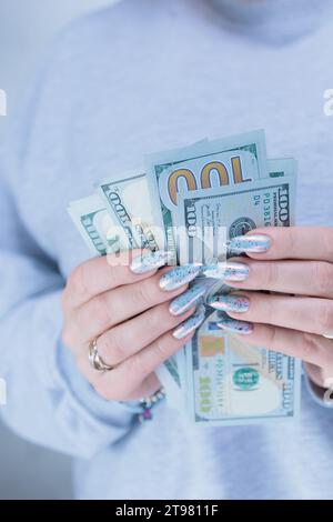 Die Hände der Frau halten amerikanische Dollarpapierscheine Stockfoto