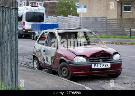 Ein ausgebranntes Auto, das schwere Brandschäden aufweist, wurde auf einer Wohnstraße hinterlassen, nachdem der Brand gelöscht wurde. Das Fahrzeug ist unreparabel beschädigt Stockfoto