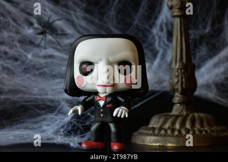 Funko Pop Actionfigur von Billy der Puppe aus dem beliebten Slasher-Horrorfilm SAW. Halloween Deko, Spinnennetz, düster, dunkel, stimmungsvoll, gruselig. Stockfoto