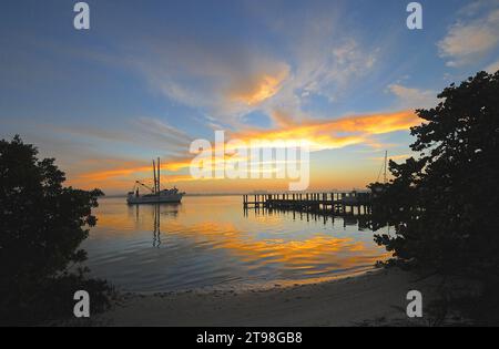 Ein Fischerboot kommt vom Meer bei Sonnenaufgang in ft. Myers Beach in Florida, USA Stockfoto