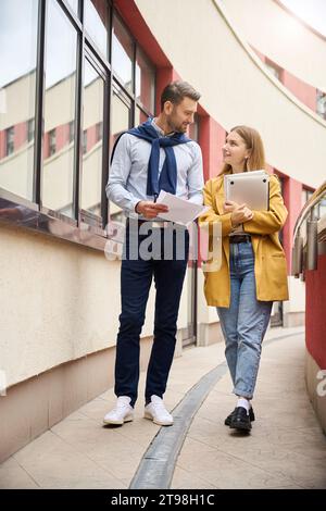 Kollegen prüfen Arbeitsdokumente auf einem großen Balkon Stockfoto