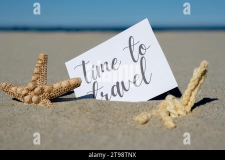 ZEIT FÜR REISEN Text auf Papiergrußkarte auf Hintergrund der Seesterne Muschel Sommerurlaub Dekor. Sandstrand, Sonnenküste. Postkarte zum Urlaubskonzept. Geschäftskonzept „Getting Away Travel“ Stockfoto