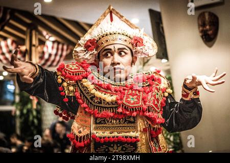 Ein männlicher balinesischer Tänzer tanzt einen traditionellen balinesischen Tanz in traditioneller balinesischer roter Kleidung in einem Café in Shanghai, China Stockfoto