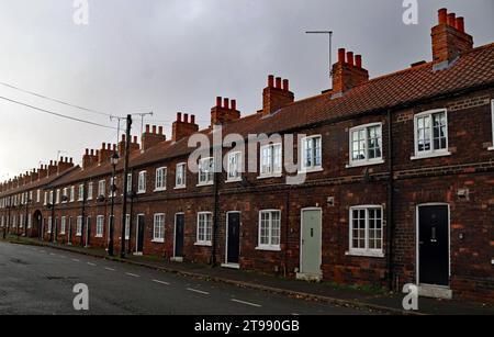 Fenster, Türen und Schornsteine von Reihenhäusern auf einer breiten Cliff Street, die Teil des Dorfes New Frodingham in Scunthorpe in Lincolnshire ist. Stockfoto
