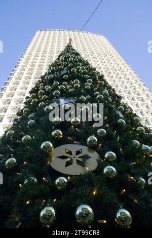 London, 23. November 2023: Ein geschmückter Weihnachtsbaum vor dem Centrepoint-Gebäude an der Kreuzung von Oxford Street, Charing Cross Road und Tottenham Court Road. Der Name Centrepoint wird auch mit einer Wohltätigkeitsorganisation für Obdachlose in Verbindung gebracht. Anna Watson/Alamy Live News Stockfoto