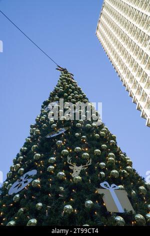 London, 23. November 2023: Ein geschmückter Weihnachtsbaum vor dem Centrepoint-Gebäude an der Kreuzung von Oxford Street, Charing Cross Road und Tottenham Court Road. Der Name Centrepoint wird auch mit einer Wohltätigkeitsorganisation für Obdachlose in Verbindung gebracht. Anna Watson/Alamy Live News Stockfoto