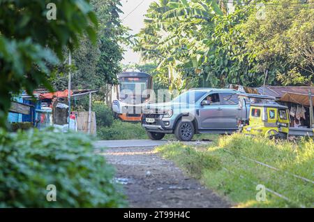 Manila, Philippinen. 24. November 2023: Railroad Crossing mit einem Auto und einem Dieselzug der Klasse PNR 8000, der seit 2019 als Interprovincial Pendler von den Philippine National Railways (PNR) betrieben wird, die heute ihr 131-jähriges Jubiläum feiern. Die Philippinen führen derzeit einen ehrgeizigen Eisenbahnausbau durch, bei dem ab Januar 2024 der Betrieb in der National Capital Region (Metro Manila) für fünf Jahre eingestellt wird, von dem täglich etwa 30.000 Filipinos betroffen sein werden, um dem Bau des North-South Commuter Railway (NSCR)-Projekts Platz zu geben. Quelle: Kevin Izorce/Alamy Live News Stockfoto