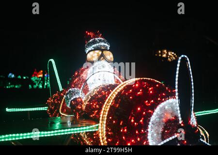 Leuchtende Weihnachtsfiguren. Santa Claus auf einer Helikopterglühanlage. Weihnachtliche Straßendekoration aus Girlanden Stockfoto