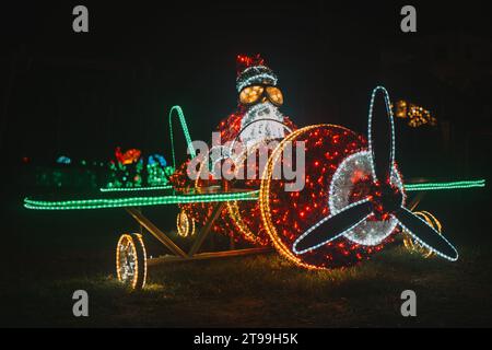 Der Weihnachtsmann im Hubschrauber. Weihnachtliche Straßendekoration aus Girlanden. Glühende Weihnachtsfiguren Stockfoto