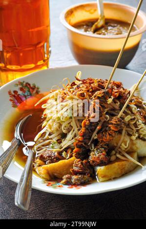 Lontong Mie ist ein traditionelles Essen aus Java, Indonesien. Hergestellt aus Nudeln und Reis, gekocht in Bananenblättern, serviert mit köstlicher Sauce mit spro Stockfoto