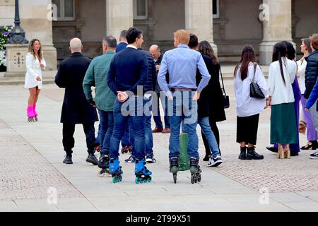 Die spanische Braut sieht zu, während die Gäste auf einen Fotografen warten, der ein Gruppenfoto vor dem Concello da Coruña, Maria Pita Platz, La Coruna arrangiert. Stockfoto