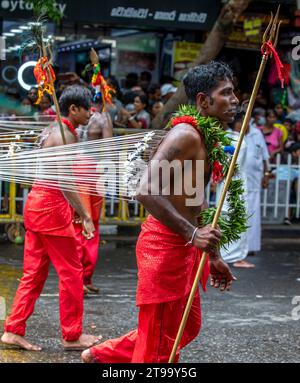 Hinduistische Kavadi-Tänzer mit Haken, die sich in die Haut stechen, treten während des Day Perahera auf den Straßen von Kandy in Sri Lanka auf. Stockfoto