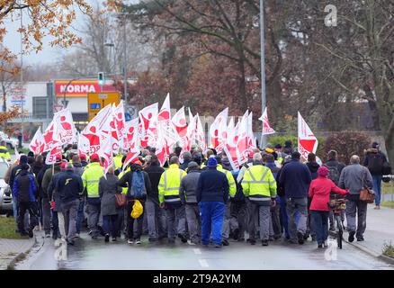 23. November 2023, Brandenburg, Fürstenwalde: Mitarbeiter des Reifenherstellers Goodyear demonstrieren nach einer Werkssitzung vor dem Werk mit Flaggen der IG BCE (Bergbau, Chemie und Energie). Nachdem das Unternehmen angekündigt hatte, 750 Arbeitsplätze am Standort Fürstenwalde abzubauen, nahm der betriebsrat Goodyear während der Sitzung Stellung zu den Plänen des Unternehmens. Foto: Soeren Stache/dpa Stockfoto