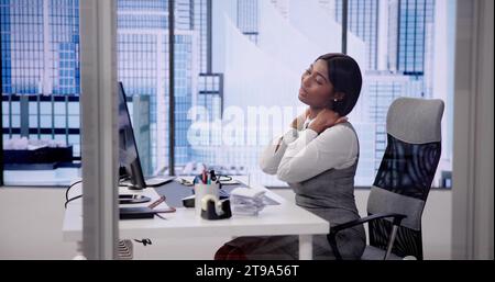 Verbesserung Der Büroergonomie: Frau Korrigiert Schlechte Körperhaltung Stockfoto