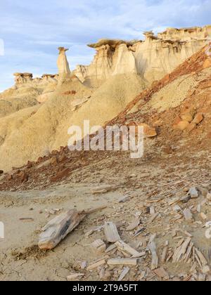 Versteinertes Holz im Vordergrund erodierter, sich wandelnder Hoodoos-Felsformationen in der Abenddämmerung in den Bisti-Badlands in der Nähe von farmington, New mexico Stockfoto