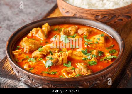 Leckeres Lahori Hühnchen Karahi serviert mit Reis Nahaufnahme auf dem Holzbrett auf dem Tisch. Horizontal Stockfoto