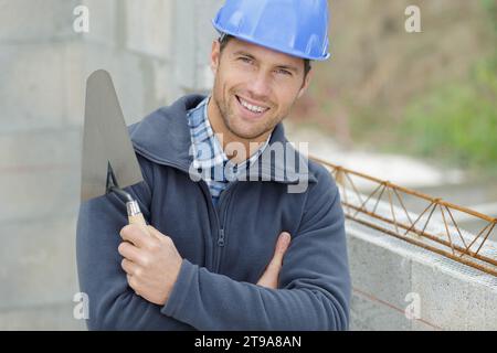 Porträt eines männlichen Baumeisters, der eine Kelle hält Stockfoto