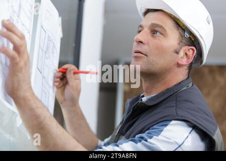 Der Designer arbeitet im Büro und macht Notizen zu den Zeichnungen Stockfoto