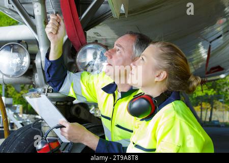 flughafenmitarbeiter überprüfen ein Flugzeug auf Sicherheit Stockfoto