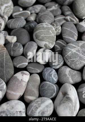 Unterschiedlich große graue Kieselsteine mit Quarzschichten innen für vertikale Stockwerke Stockfoto