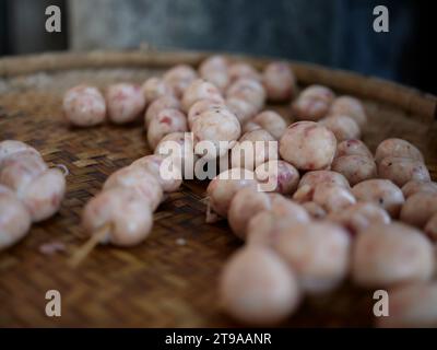 THAILÄNDISCHE ISAAN-WURST. E-sarn Würstchen, hausgemachte Sauerwürste. Rohes hausgemachtes Schweinefleischwürstchen in Schalen mit Kräutern und Gewürzen. Stockfoto