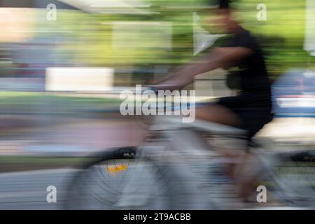 Geschwindigkeit, Bewegung und Radfahren. Verwendung von Kameraschwenken und niedriger Verschlusszeit, um einen Eindruck von Geschwindigkeit und Bewegung in einer städtischen Umgebung zu vermitteln Stockfoto