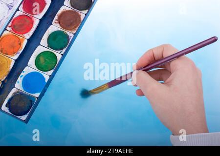 Aquarellfarbe in Wasser auflösen, wie Malerei Pinsel Wasser berührt Stockfoto