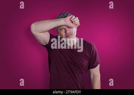 Menschen, Krise, Emotionen und Stresskonzept. Unglücklicher, trauriger Mann, der an Kopfschmerzen leidet Stockfoto
