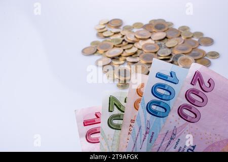 Türkische Lira-Münzen und-Banknoten nebeneinander auf weißem Hintergrund Stockfoto