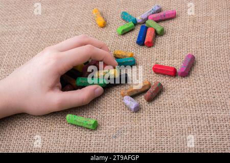 Benutzte Farbstifte und eine Hand, die etwas hielt Stockfoto