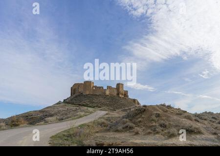 Eine unbefestigte Straße führt zur spektakulären Burg Montearagon in Huesca, einer mittelalterlichen Burg, die mehrere hundert Jahre alt ist Stockfoto