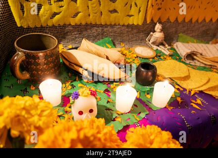 Ein Tag des toten Altars mit Schädeln, Cempasuchil-Blumen, Essen und Kerzen Stockfoto