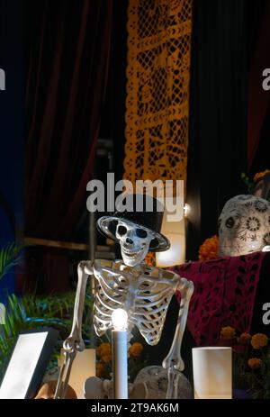 Ein menschliches Skelett, dekoriert für den Tag der Toten in mexiko mit Papel Picado im Hintergrund Stockfoto