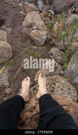 Ein Fuß eines Mannes ohne Schuhe, der auf einen Berg klettert Stockfoto