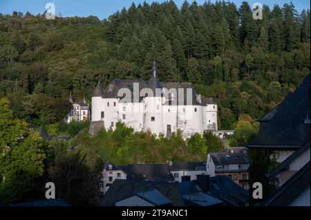 Blick auf die Gemeinde Clervaux mit Stadtstatus im Norden Luxemburgs und grünen Wald, Hauptstadt des Kantons Clervaux, weißes Schloss bei Sonnenuntergang Stockfoto