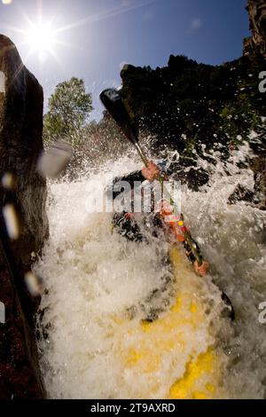 Nahaufnahme eines männlichen Kajakfahrers, der aus einem Schnellboot explodiert. Stockfoto