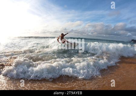 Ein Mann beim Skimboarding in nettem Licht. Stockfoto